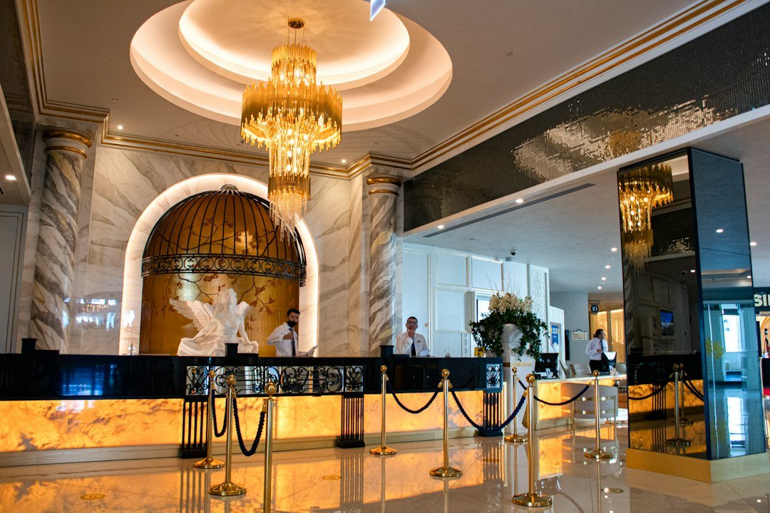 An elegant hotel reception with marble detailing and a chandelier